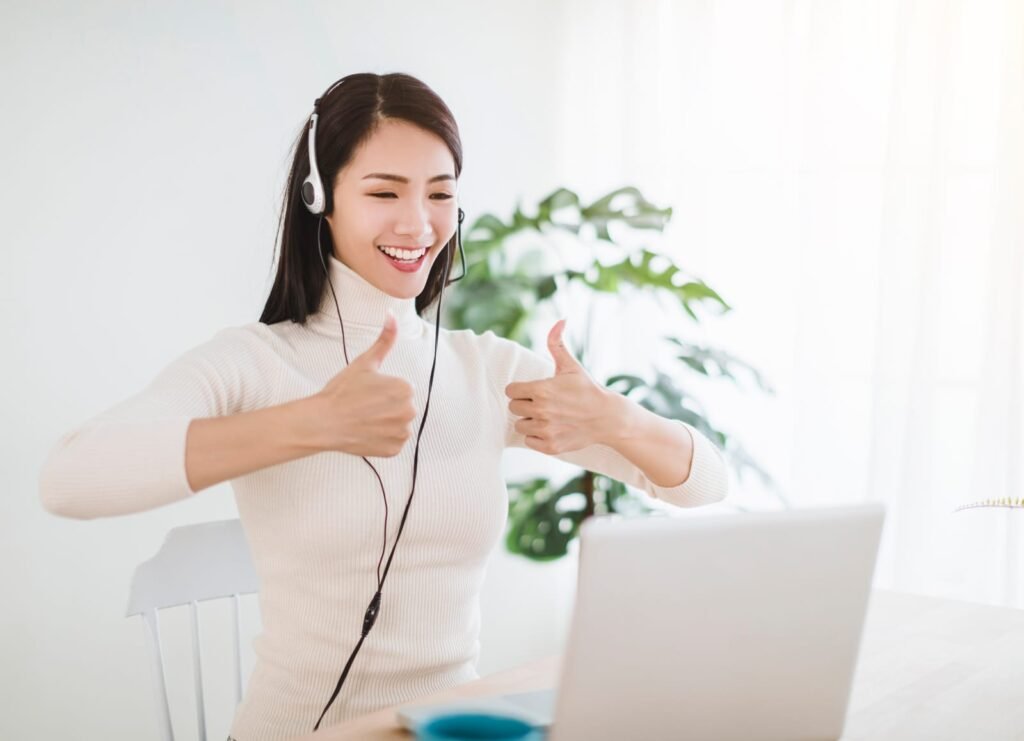 Young woman working on laptop and using video call in living room at home – Online Vet vs. Emergency Room
